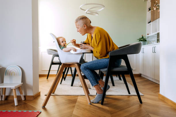 istock Mother spoon feeding her baby boy at home 2159656008
