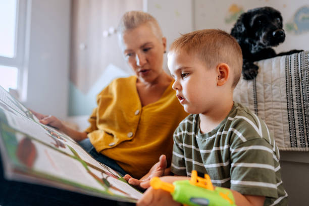 istock Mother and son reading book while sitting on a floor at home 2159656147