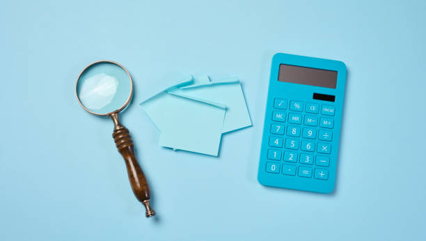 istock Magnifier and calculator on a blue background, budget calculation. 2159657329