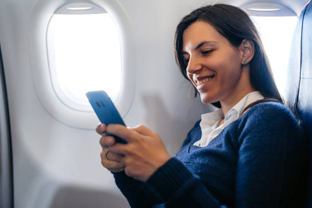 istock Young Woman Using Her Smart Phone In An Airplane 2159657932