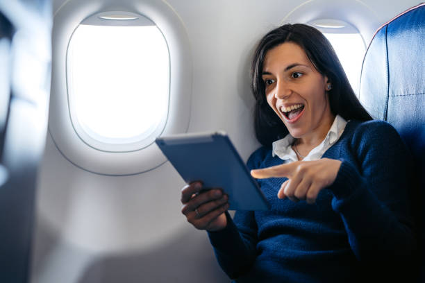 istock Young Woman Watching Something Funny On The Digital Tablet In An Airplane 2159658061