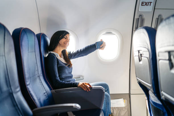istock Young Woman Taking Selfies Using Her Smart Phone In An Airplane 2159658602