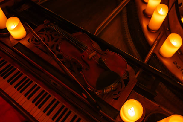 istock Violin on pianoforte with candles 2159658878