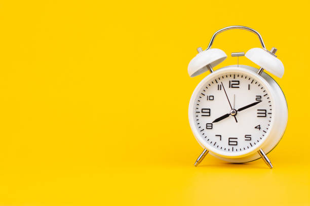 istock Alarm clock. Stationary photo in studio on yellow background, time concept. 2159658942