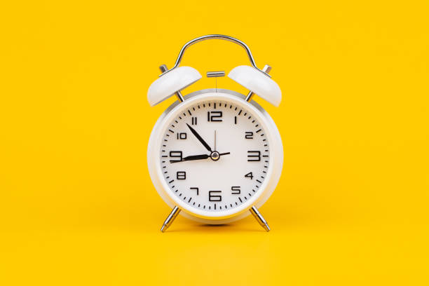 istock Alarm clock. Stationary photo in studio on yellow background, time concept. 2159658944