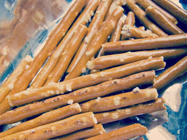 istock Dry, baked, long, salted sticks on shiny foil 2159661240