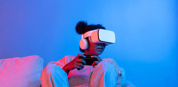 istock Smiling African playing gaming player wearing VR control joystick. Contrivance. 2159663031