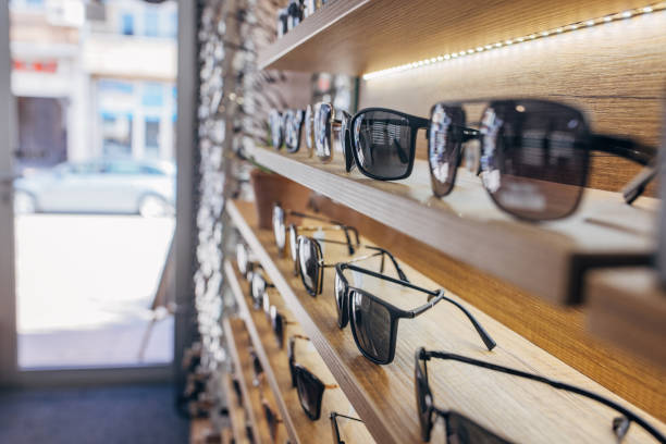 istock Luxurious sunglasses on wooden shelves with sunlight 2159663249