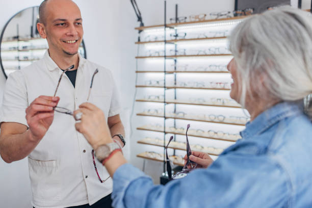 istock Optical store staff assisting woman with glasses. 2159664320