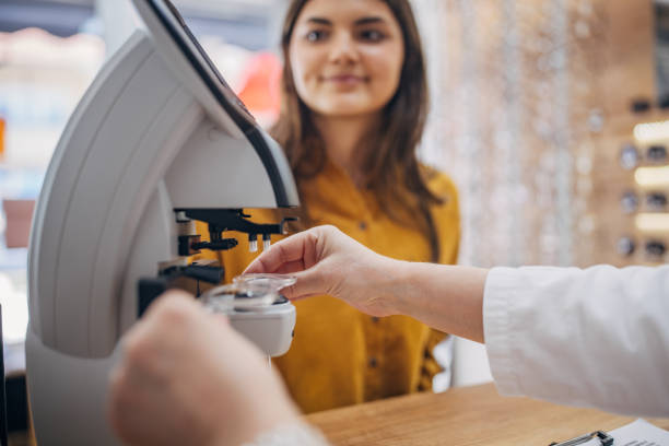 istock Optician adjusts eyeglasses closely for a customer 2159664369