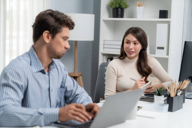 istock Smart manager talking to woman coworker while typing on laptop. Postulate. 2159665183