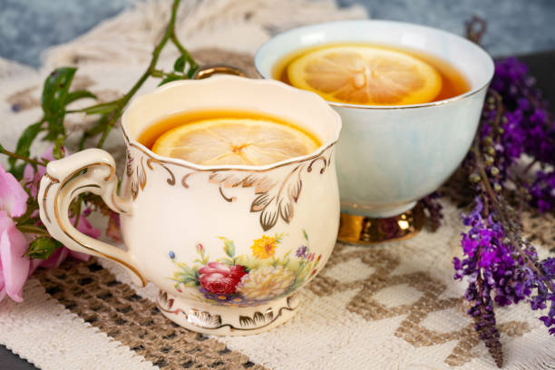 Close-up shot of unrecognizable senior man pouring sugar into tea while relaxing with his wife in the living room at home