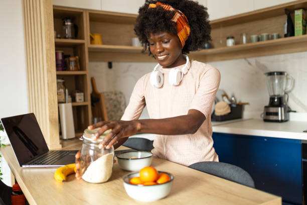 istock Young woman preparing breakfast in a modern kitchen 2159667603