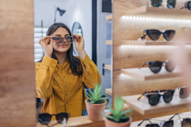 istock Person trying on glasses in front of mirror display. 2159669743