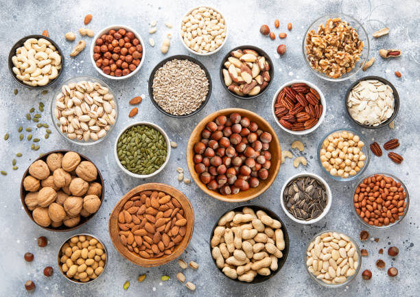 istock Mixed assorted raw healthy nuts and seeds in various bowls on light kitchen background.Peanut,hazelnut,walnut,almonds,pistachio,sunflower,pumpkin,chia and cashew.Top view. 2159672760