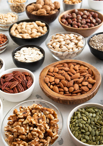 istock Mixed raw nuts and seeds in bowls on kitchen table.Peanut,hazelnut,walnut,almonds,pistachio,sunflower,pumpkin,chia and cashew.Macro 2159672856