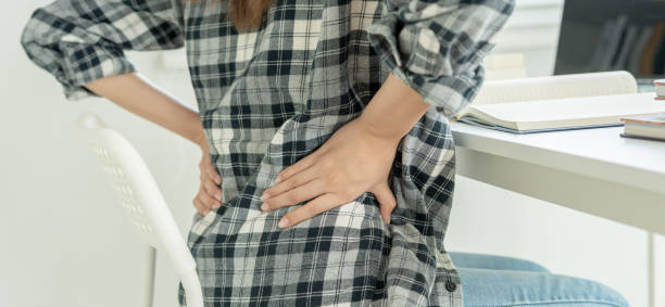 istock woman holding her lower back while and suffer from unbearable pain health and problems, chronic back pain, backache in office syndrome, scoliosis, herniated disc, muscle inflammation 2159672896