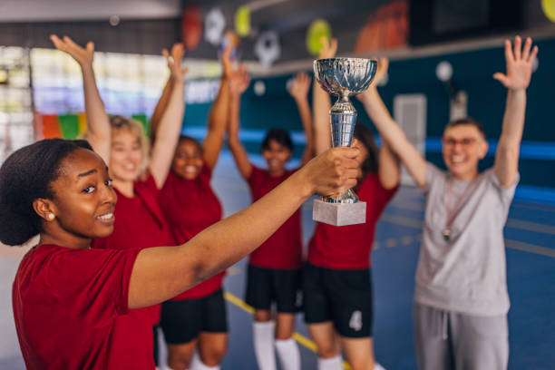 istock Triumphant team raising the trophy in joyful cheer 2159673474