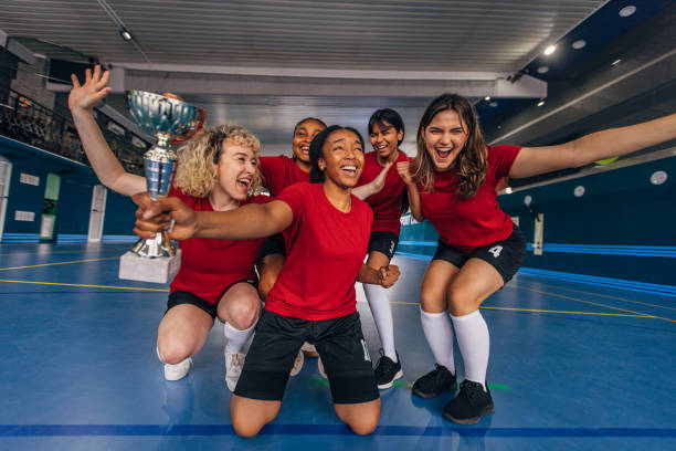 istock Winning team celebrates victory with indoor trophy. 2159675163