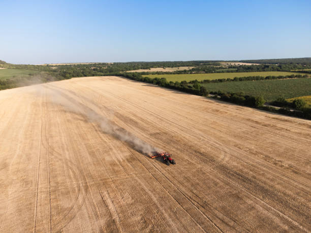 istock Red tractor on a harvested field 2159675564