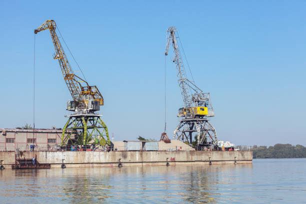 Yellow green portal cranes stand on a quay in harbor of Ruse Port, Bulgaria