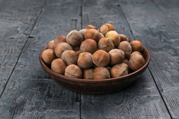 istock Bowl of Hazelnuts on Rustic Wooden Table 2159676979