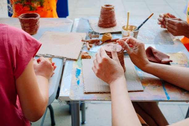 istock A student in a pottery class shapes clay into a pot. 2159678009