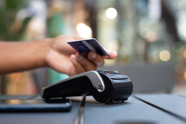 istock man paying contactless with creditcard in restaurant. 2159678479