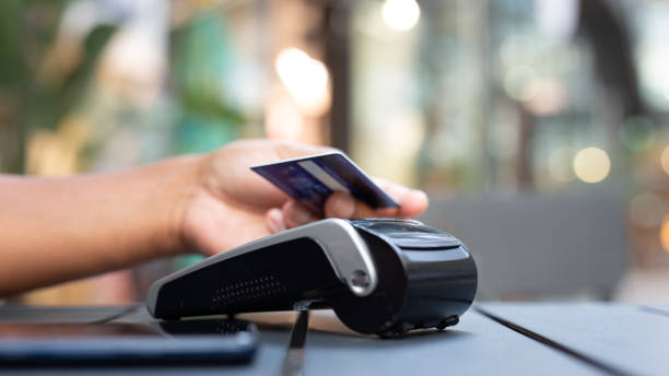 istock man paying contactless with creditcard in restaurant. 2159678481
