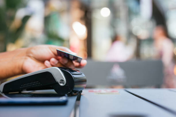 istock man paying contactless with creditcard in restaurant. 2159678494