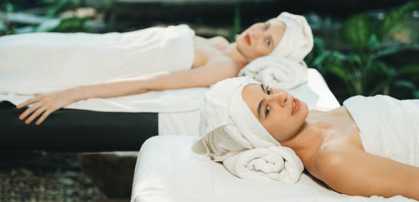 istock Two beautiful young woman lie on bed rounded by peaceful nature. Tranquility. 2159678728
