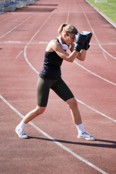 istock young female boxer training in the stadium, standing in position 2159679162