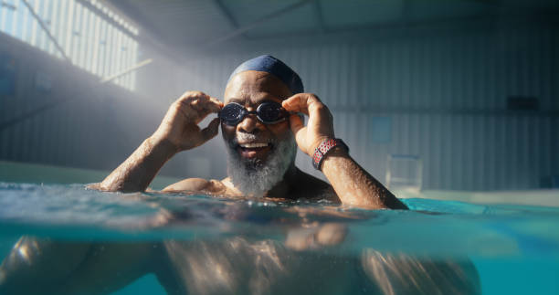 istock Senior, black man and goggles in swimming pool for exercise, physical therapy and physiotherapy for arthritis management. Happy person, indoor aquatic center and hydrotherapy for mobility strength. 2159682043