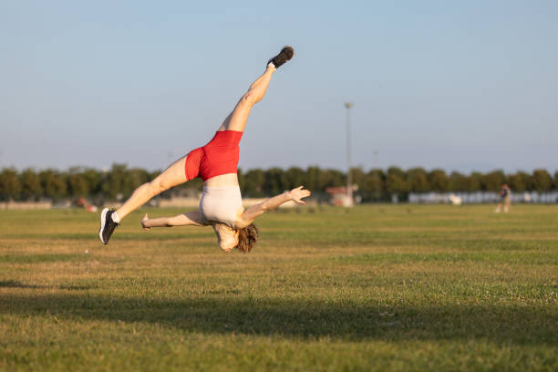 istock Gymnast woman is jumping on the grass. 2159682867