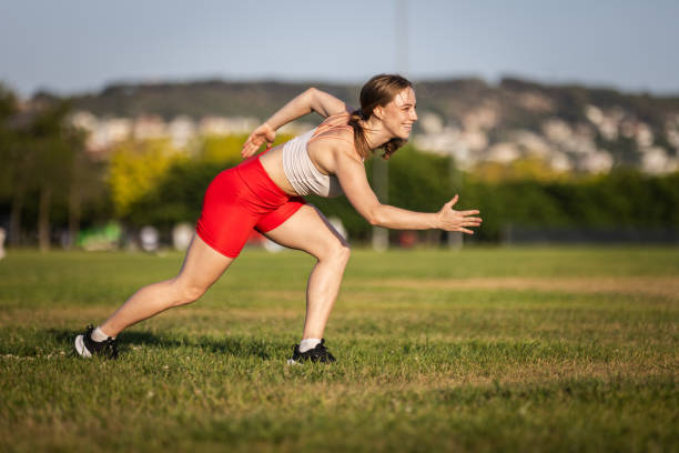 Rear view of female athlete preparing to throw shot put ball in stadium
