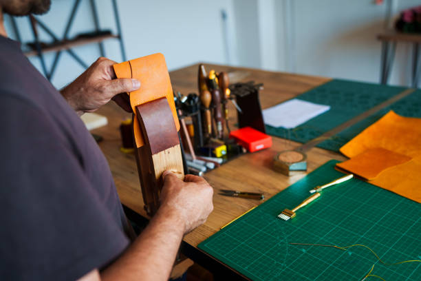 istock Craftsman is sewing leather in vice 2159684558