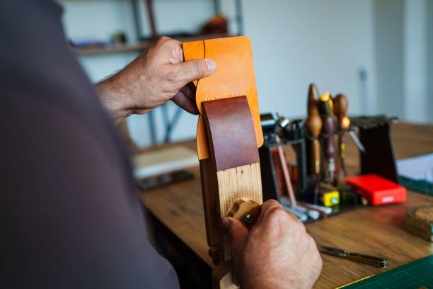 istock Craftsman is sewing leather in vice 2159684559