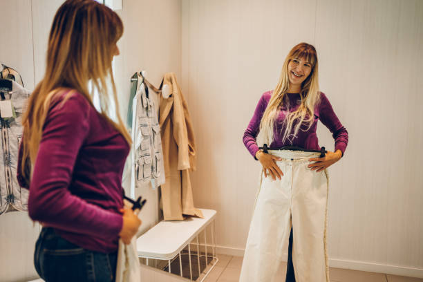 Young cheerful woman trying clothes in a dressing room.