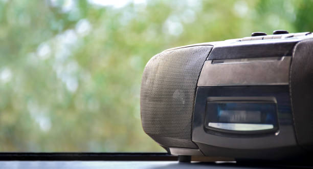 Cassette and CD player Cassette and CD player in 1990 style on window with natural blurred background. 1990’s vintage life style concept. open cd player stock pictures, royalty-free photos & images