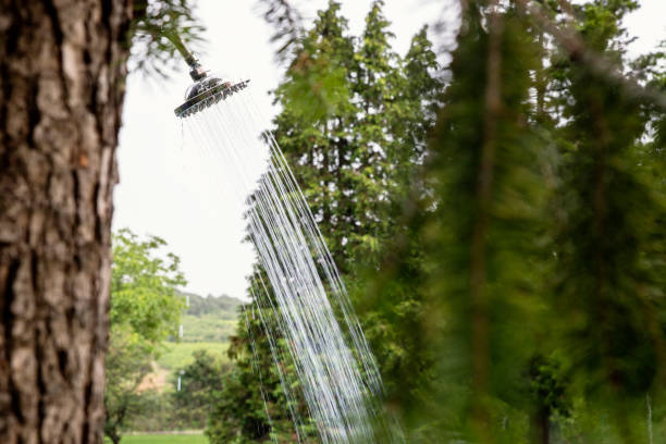 Outdoor shower head spraying water on Summer day