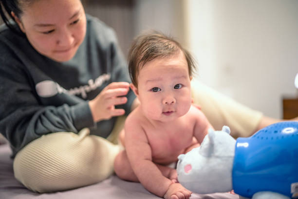 Mother and baby are playing on the bed