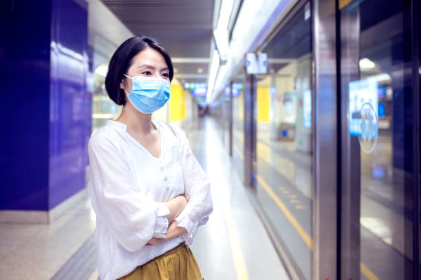 istock Asian woman with protective face mask waiting for subway MTR train in platform 2159699424