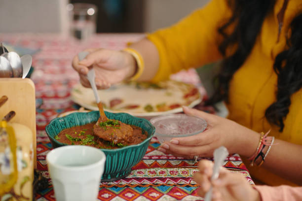 The photo focuses on the food on the tray, following the female waiter's gaze to the table in the cafe. This delicious plate is about to be served to a beautiful mature Asian woman sitting at the dining table.