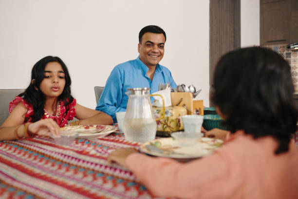 istock Family Sitting At Dining Table 2159700280