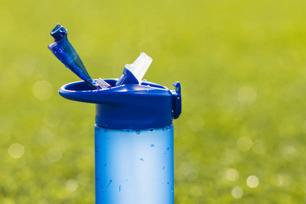 A water bottle placed on a table with rice paddies in the background.