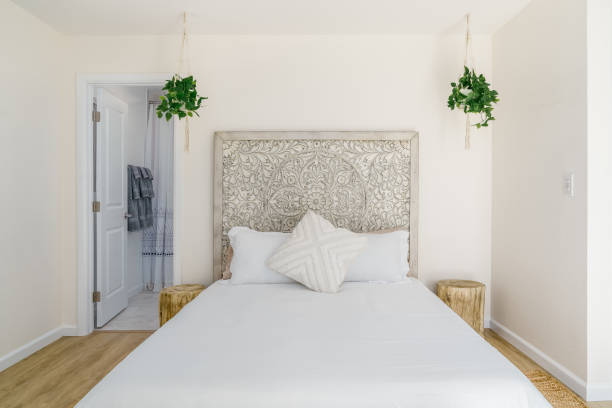 istock boho modern bed and carved wood headboard and tree stump side table 2159701881