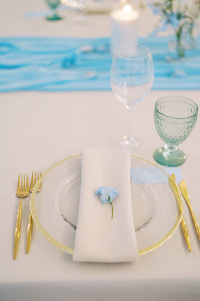 istock Blue delphinium flower lies on a napkin on a plate on a set table 2159706016