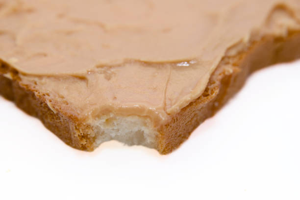 A close-up photo of a slice of bread with peanut butter spread on it