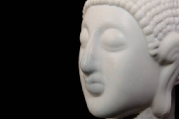 istock Close up of white buddha statue isolated on black background 2159708280