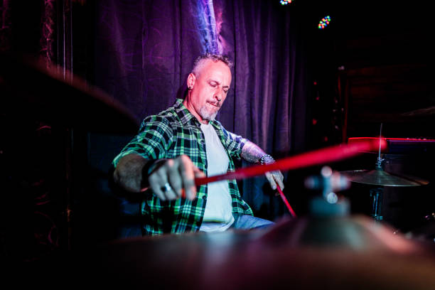 Mature man playing drum kit on a live concert